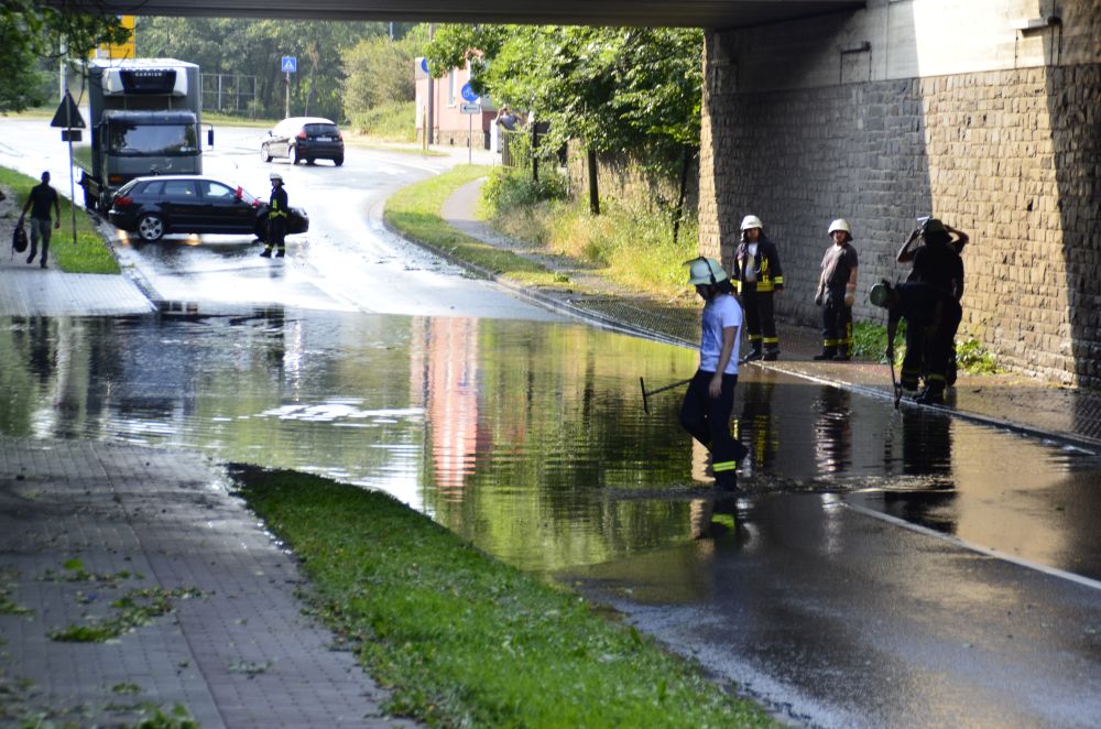 Dieses Bild zeigt eine überflutete Unterführung in der Stadt Euskirchen nach einem Gewitterdurchzug. Ebenfalls zu sehen sind Feuerwehrmänner die versuchen die Abflüsse freizulegen.